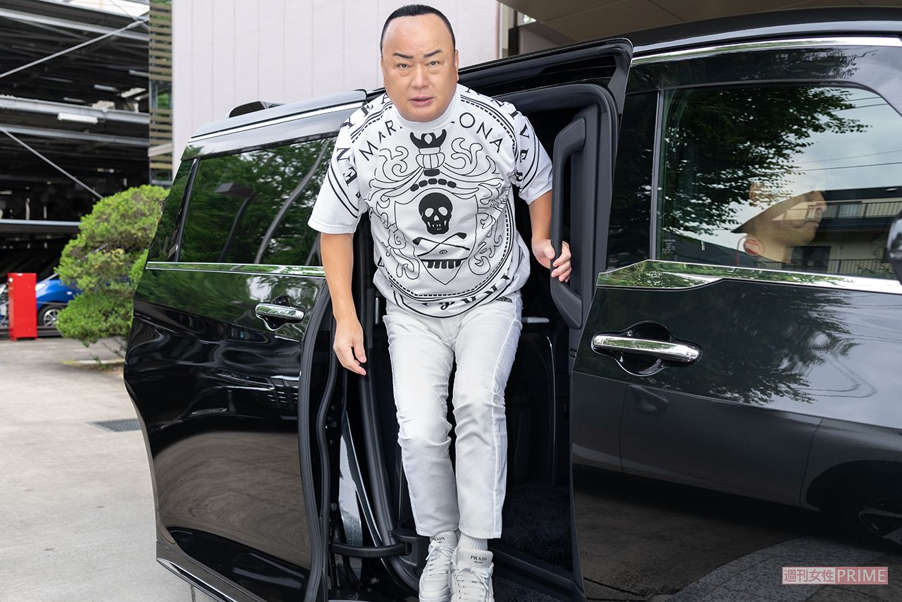 送迎車で収録現場に到着。この日の私服は、MARK&LONAの新作TシャツにPRADAのスニーカーを合わせて（撮影／佐藤靖彦）