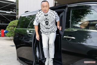 送迎車で収録現場に到着。この日の私服は、MARK&LONAの新作TシャツにPRADAのスニーカーを合わせて（撮影／佐藤靖彦）