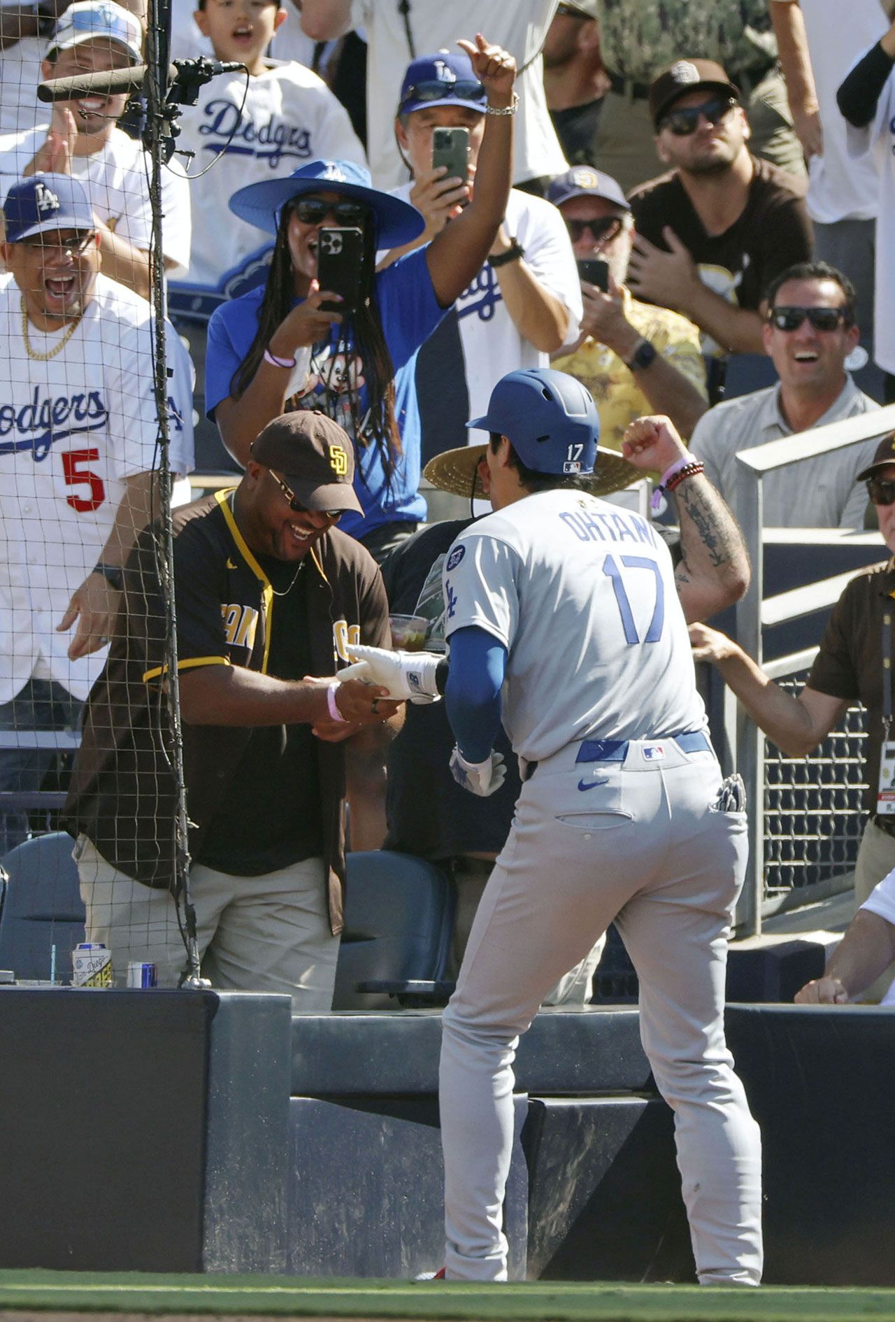 2025年8月25日、ヤジを飛ばしていたパドレスファンの男性とハイタッチする大谷翔平／共同通信