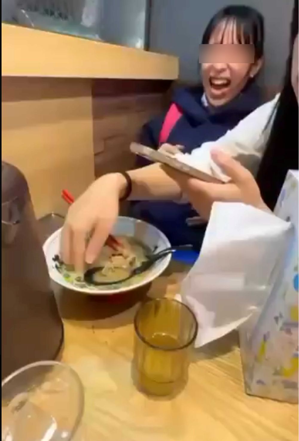 『くら寿司』で迷惑行為を行った女性（右）が素手でラーメンを触る様子