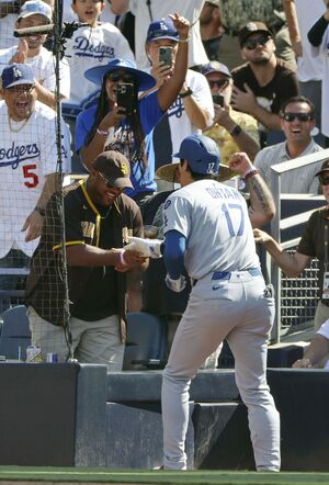 2025年8月25日、ヤジを飛ばしていたパドレスファンの男性とハイタッチする大谷翔平／共同通信