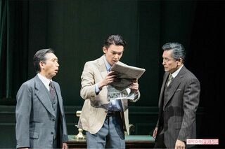 レナード（小瀧）は、自身が殺人事件の容疑者として載っている新聞を手に愕然とする　撮影／山田智絵