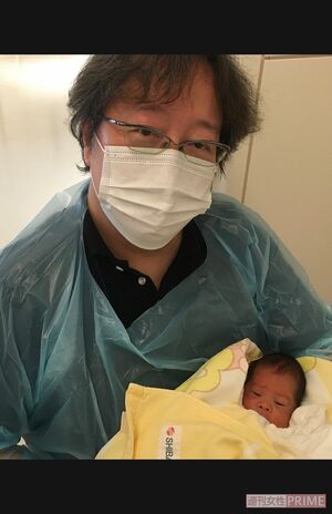 生まれたばかりの息子さんを抱っこする中本さん