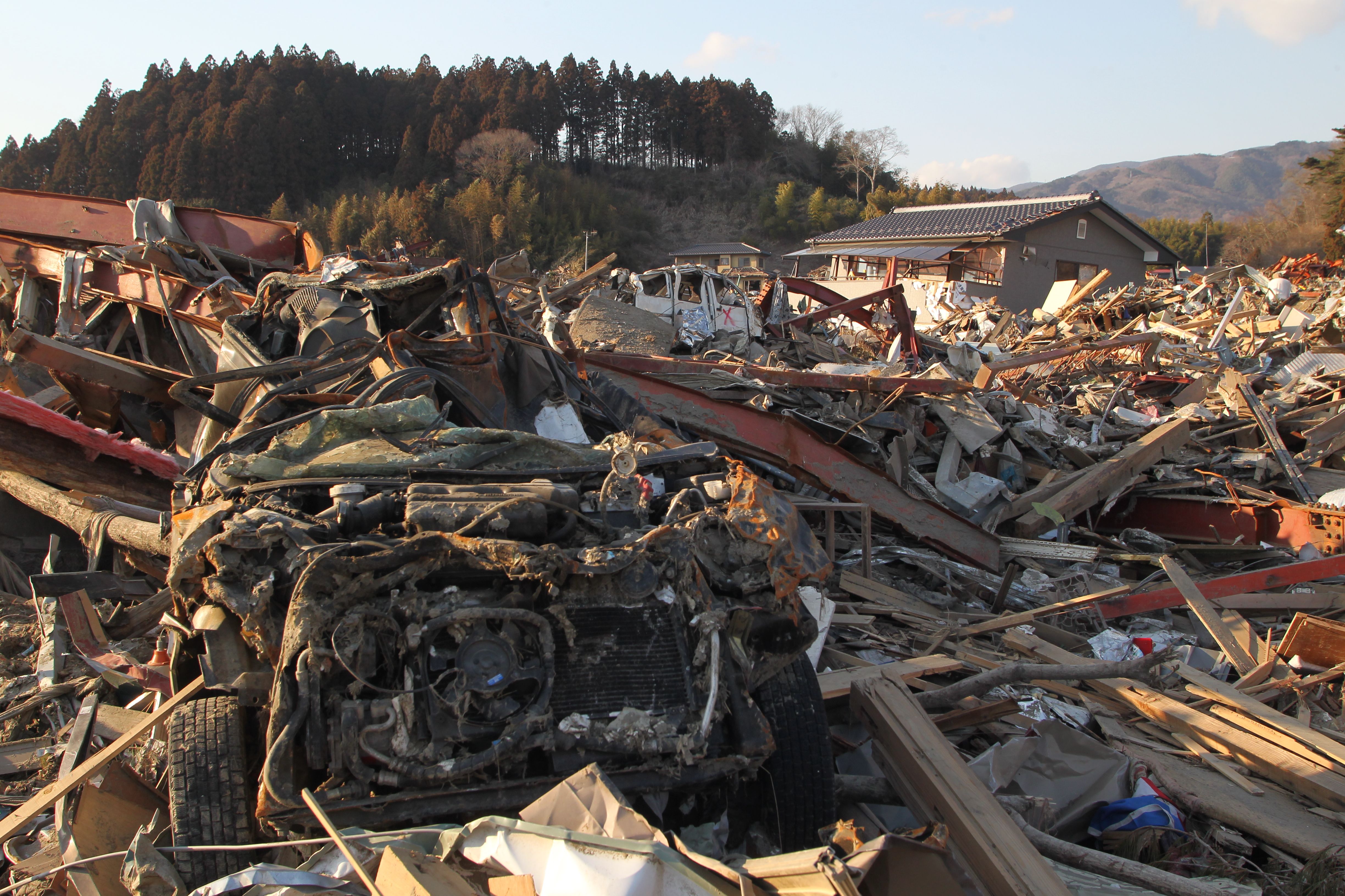 奥の車には×印が。これは遺体が発見されたことを意味し、あちこちの車や家に×印がつけられていた（陸前高田市、2011年3月29日〜4月1日）