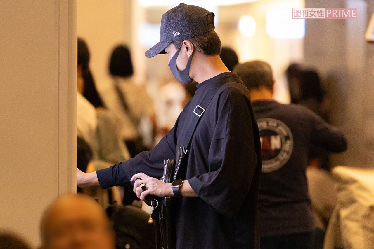 空港内の自動販売機で、飲み物を購入する赤西仁。左手薬指につけた大きな指輪は、個性的でオシャレなデザイン