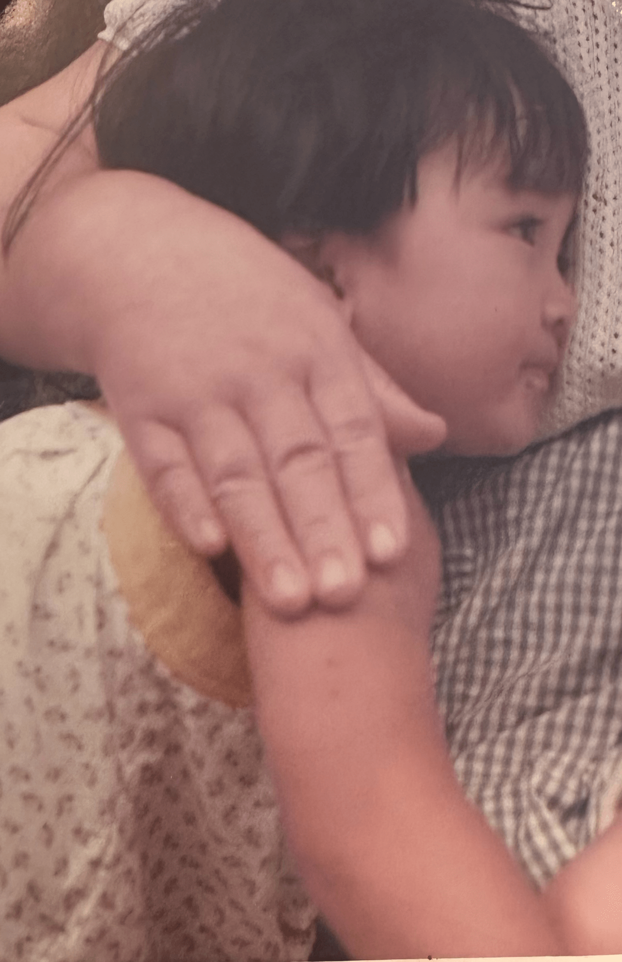 祖母の輝子さんに抱かれている2歳の北原さん