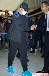 成田空港の到着ロビーにて、日本バドミントン協会の銭谷欽治専務理事と握手を交わす桃田賢斗
