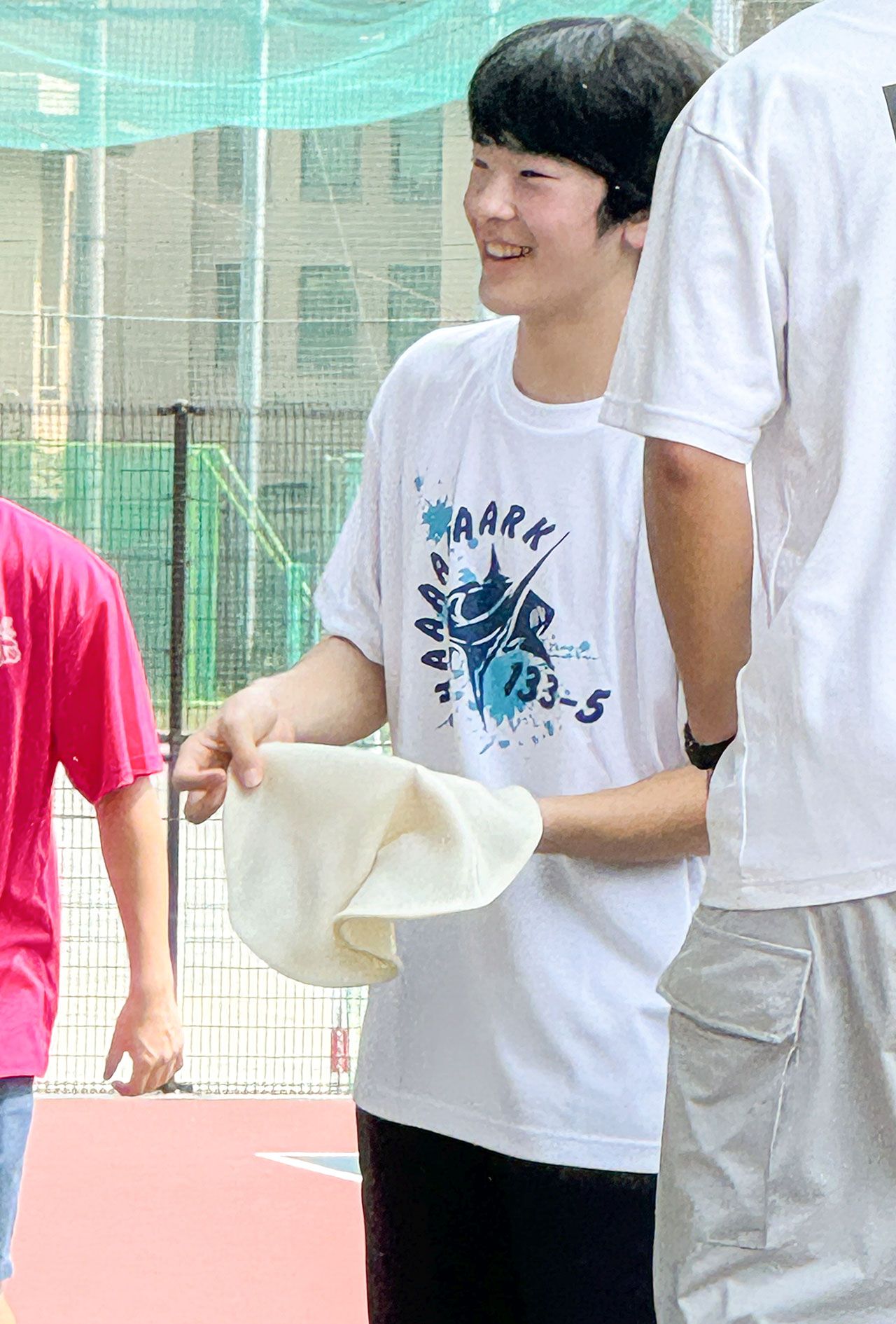 筑波大学附属高校の文化祭で、ご学友とピザ生地のようなものをくるくると回す悠仁さま（来場者提供）