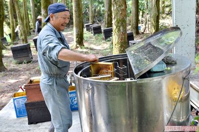 蜂の巣を遠心分離機に入れて、巣からハチミツを出す作業を行う2代目の父・栄作さん　撮影／伊藤和幸