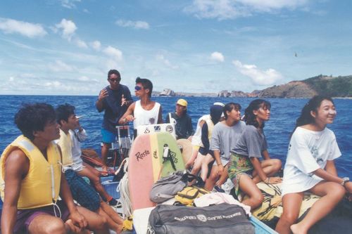 野生のイルカと泳ぐため観光客が集まった。群れを探し船を走らせる