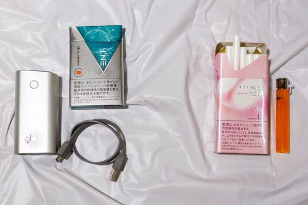 右側が従来の紙巻きタバコとライター。左側がネオスティック、グロー本体、充電用ケーブル
