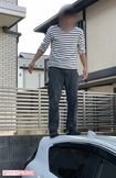 X教員の車にのぼりふざけるB教員(関係者提供)