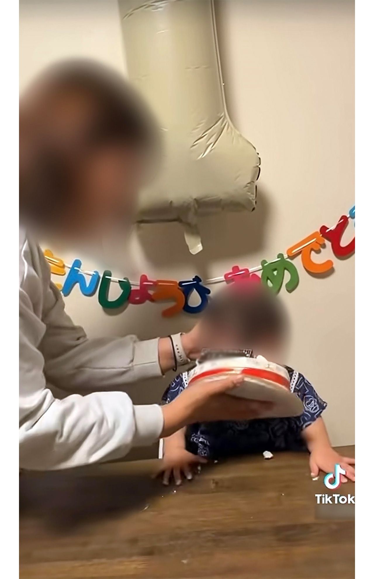 ホールケーキに何度も顔を押しつけられる幼児（母親のTikTokより）