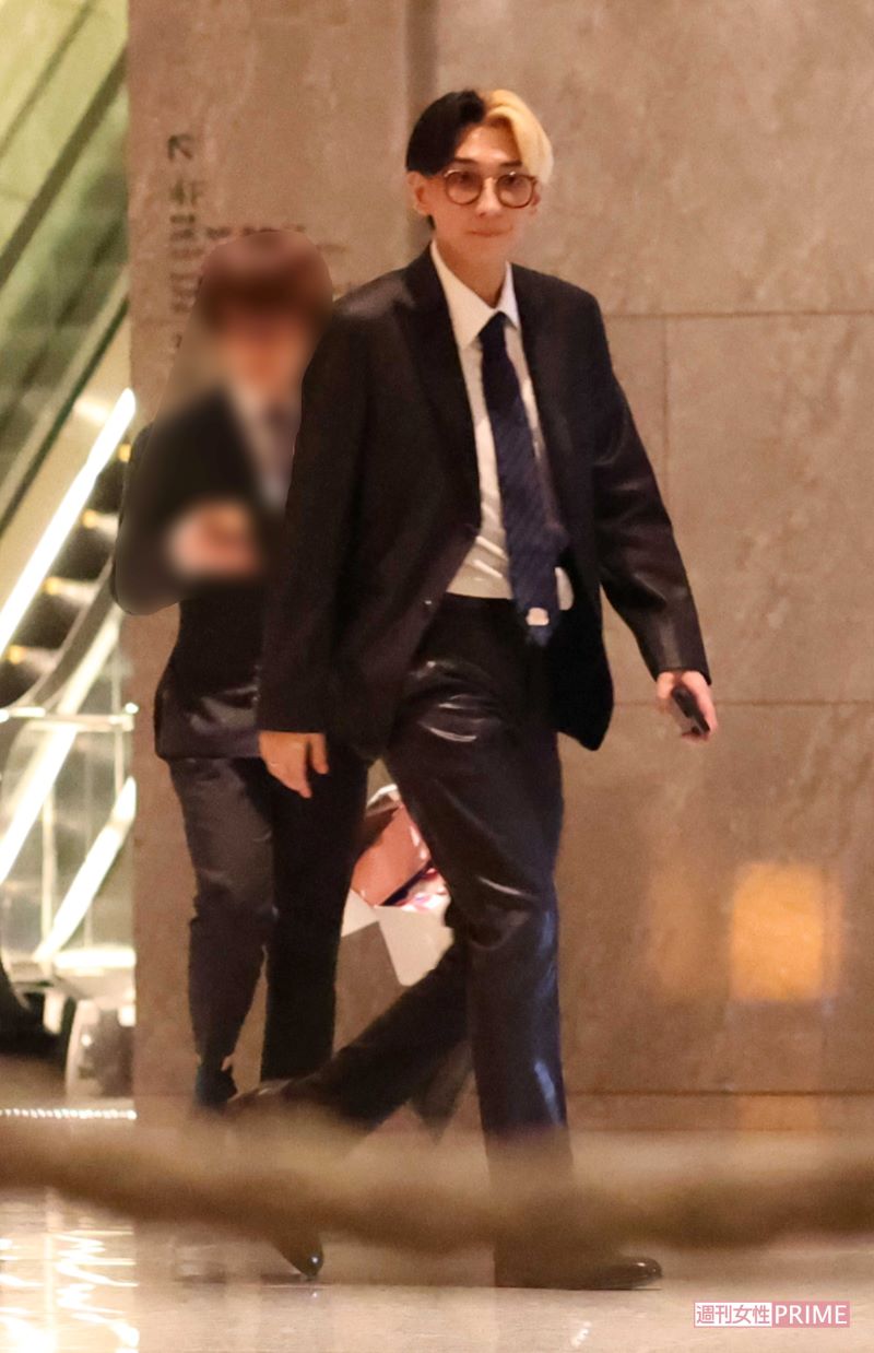 ヒカルは、シックなブラックスーツにメガネをかけたコーデで参上