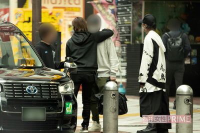 タクシーに乗り込む前、共に一夜を過ごした男性をだきしめる堂本光一（左）と見守る上田竜也（右）