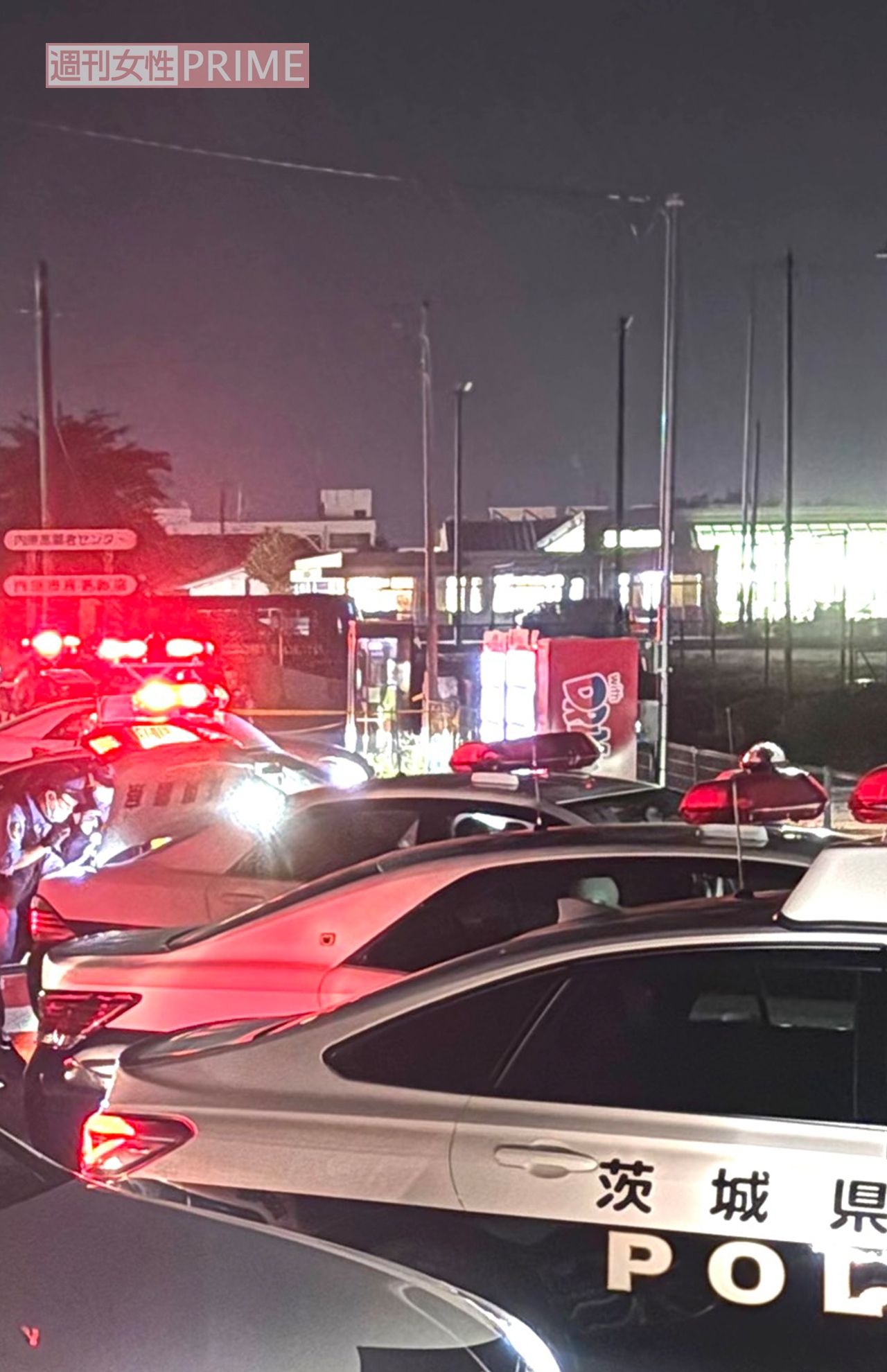 坂田武男容疑者が電話ボックスから110番通報後、身柄を拘束されたとみられる瞬間。パトカーが5、6台出動し、画像奥のパトカーの後部座席に乗せられたようだという。（読者提供）