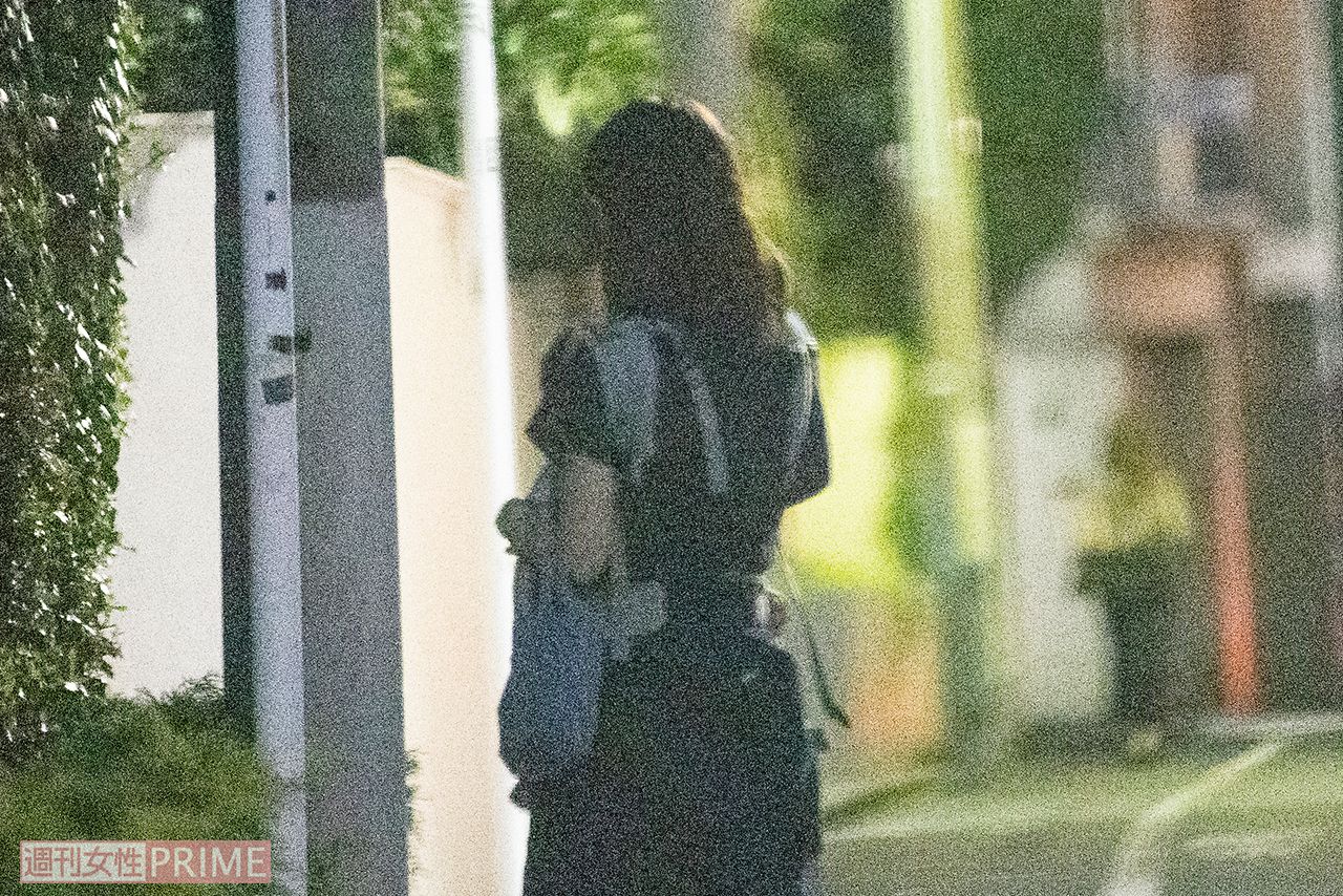 子どもを抱えながら角を曲がっていく小倉優子