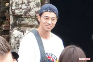 「ミーソン遺跡」を背景に写真撮影をする東出のアップ