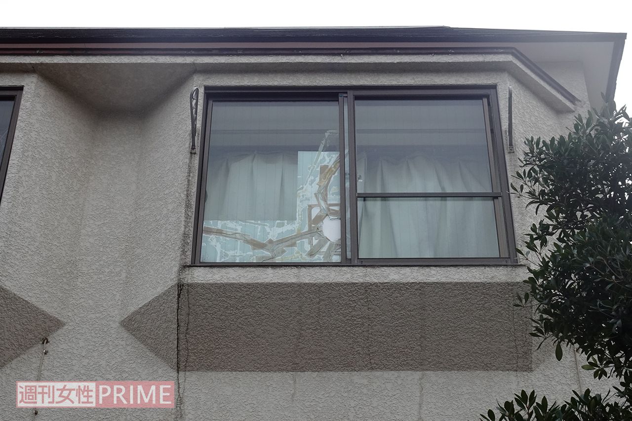 容疑者の自宅アパート。窓ガラスには大きなヒビ割れをテープでふさいだ跡が見える
