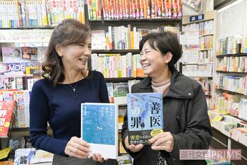 二村さんがおすすめした本を手に、常連客の飯田さんと　撮影／渡邉智裕