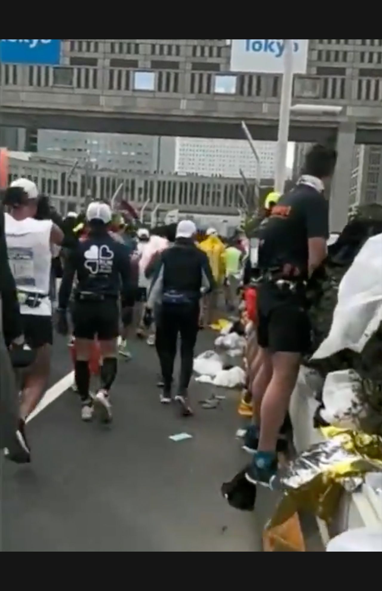 植え込みに向かって立ち小便をするランナーたち、足元を見るとずらっと並んでいることがわかる（Twitterより）