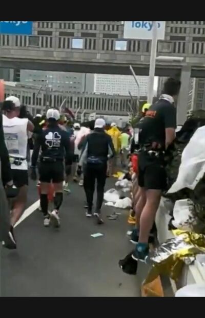 植栽に向かって立ち小便をするランナーたち、足元を見るとずらっと並んでいることがわかる（Twitterより）