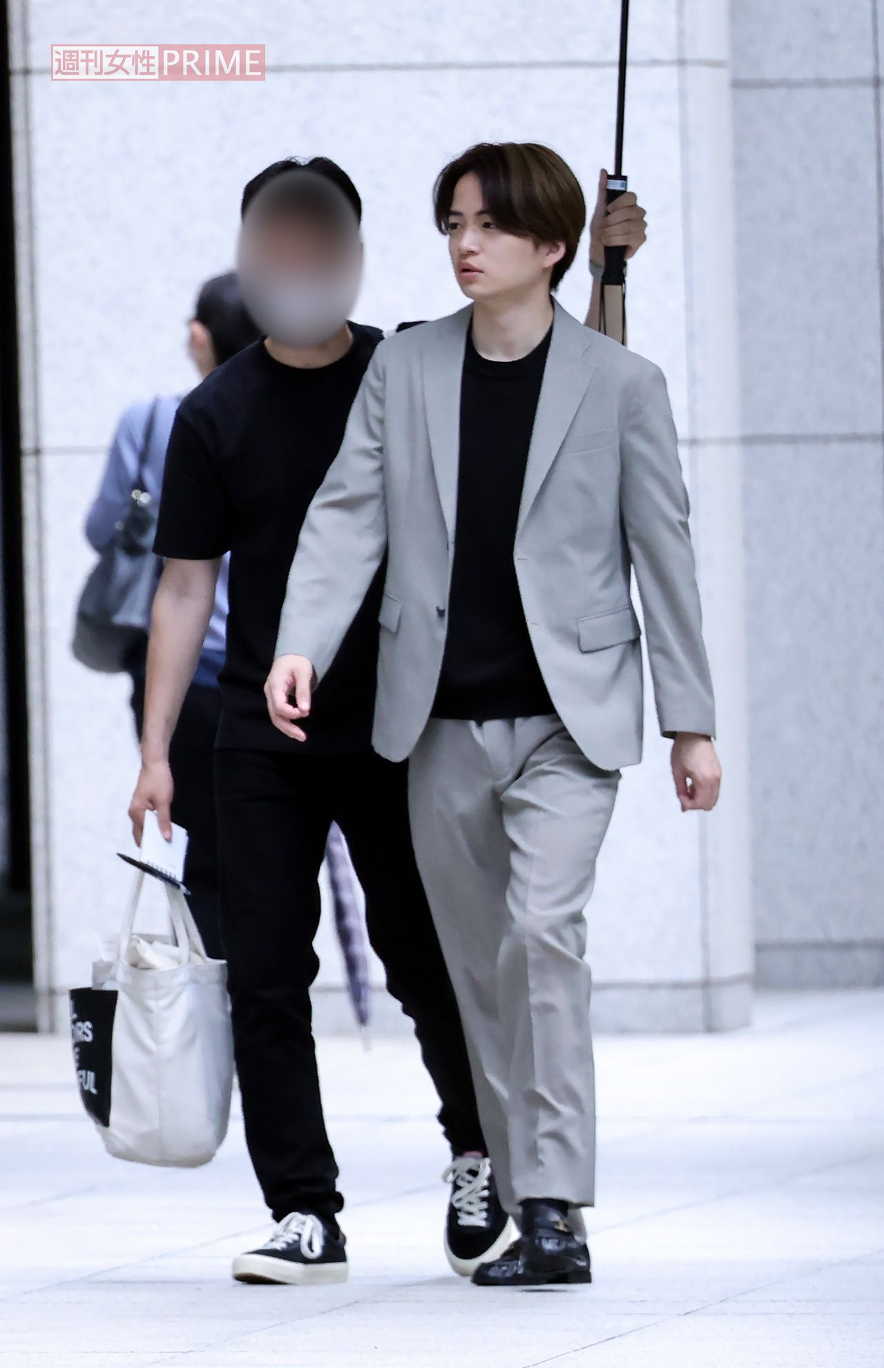 スタッフが差す日傘の下で待機している菊池風磨。朝が早い撮影だったが、眠気は一切感じさせない表情をしている