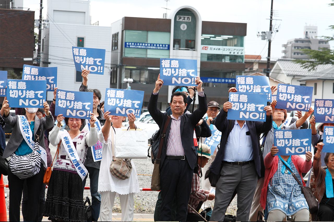 「福島切り捨てNO!!」のプラカードを掲げる生業訴訟の原告たち。判決前にデモ行進も行った　撮影／木野龍逸