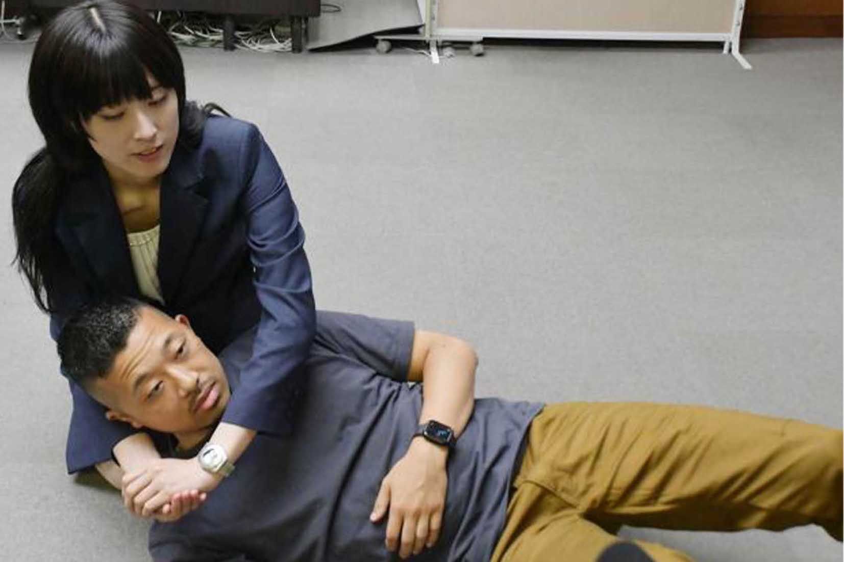 9月30日、感謝状を受け取った際、警察官を相手にヘッドロックを再現した梁さん