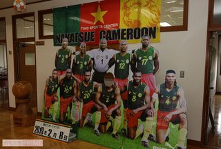 スポーツセンター内に今も設置されている、当時のカメルーン代表選手の写真ボード。来訪者が一緒に撮影できるように、真ん中のビル・チャト選手の顔が抜かれている。本人もこのボードを見て“自分の顔がない！”と驚いたそう。でも笑顔で自ら顔を出して写真撮影したとか