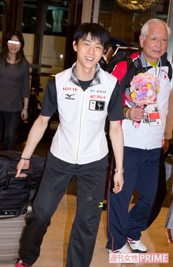 大会では、羽生のそばに常に付き添うトレーナーの菊地氏。左奥はゆづママ（'14年）