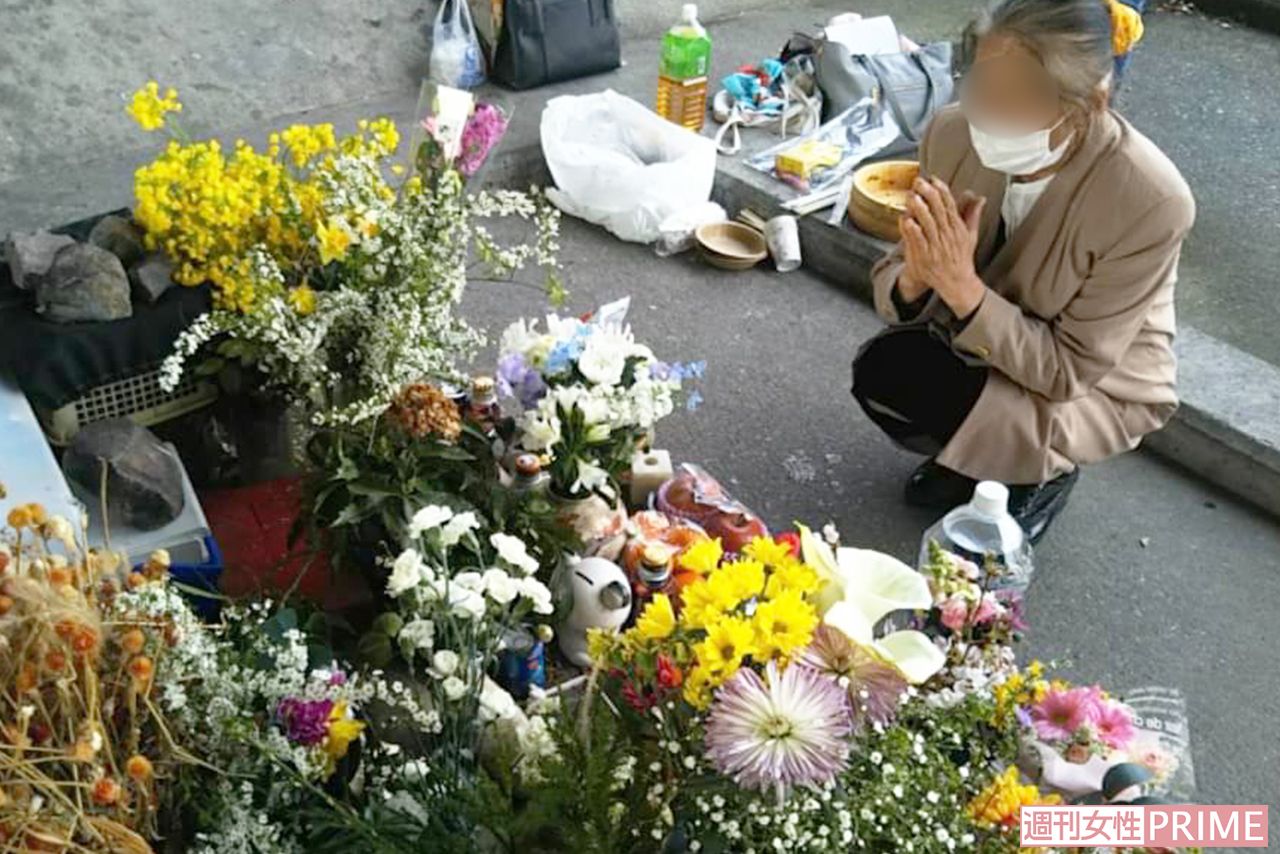河渡橋西詰の下に置かれた献花台で手を合わせるアイさん