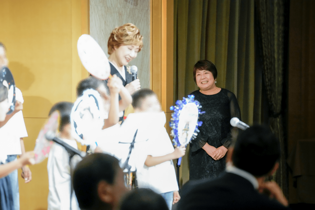 6月に行われた小林幸子さんの60周年記念祝賀会で、「こども食堂サザンクロス」を利用する子どもたちが小林さんに歌をプレゼントした