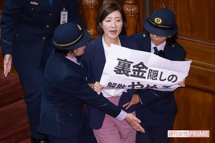 女性衛視2人に抱えられながら壇上から降ろされる大石あきこ氏（2024年10月1日、本誌写真班）