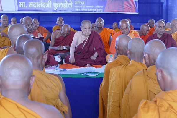 剃りたての頭に新しい僧衣を身につけた“新人坊主”たちを前にして、眼光鋭くひとりひとりの顔を見つめる佐々井さん　撮影／白石あづさ