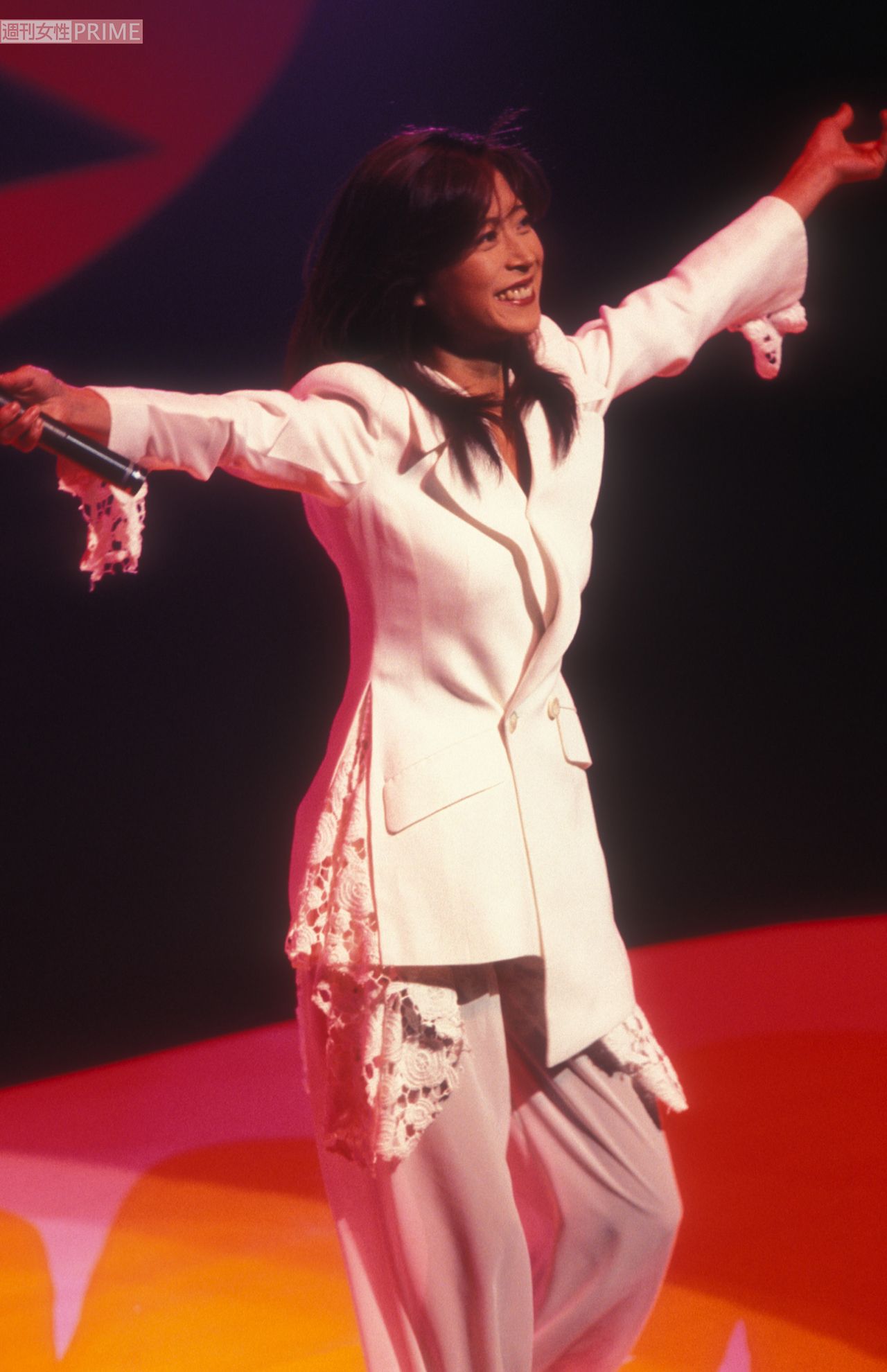 ステージで大きく手を広げ、ハジける笑顔を見せる中森明菜