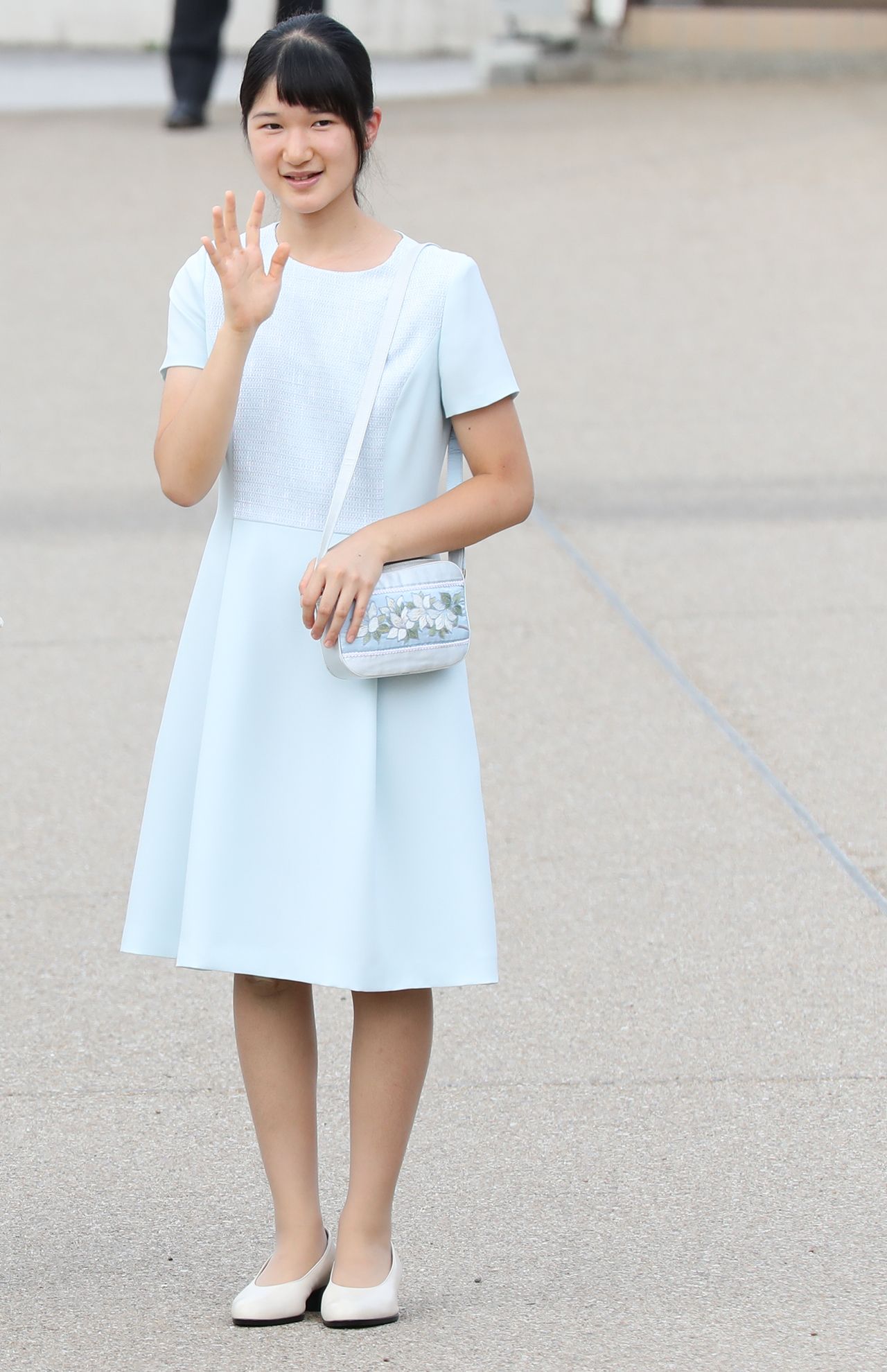 '16年7月（14歳）伊勢神宮に向かわれる、橿原神宮前駅で。襟なしのプレーンなワンピースは、グレーがかった凹凸のあるテキスタイル。「バッグのお花は愛子さまのお印“ゴヨウツツジ”。今年3月の伊勢神宮ご参拝時にもお持ちでした」（撮影／JMPA）