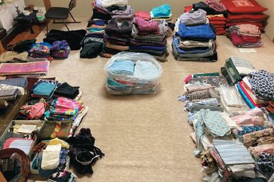 1枚ずつ出しながら状態を確認して、寄付できる衣類（上）、小物類（左）、布地（右）、資源ゴミ（袋の中）と分類した