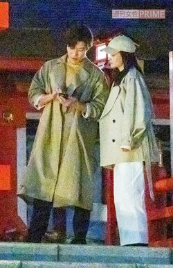 2月中旬、『シティーハンター』ロケでスマートフォンを見ながら、黒木メイサ（写真右）と打ち合わせをする鈴木亮平