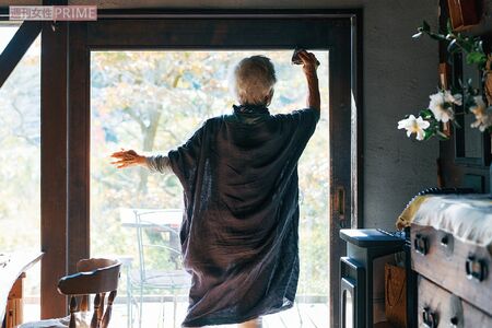 窓を掃除する信田さん。すぐ掃除できるように、掃除道具はキッチン入り口に出しっぱなし。心地よい生活には軽いフットワークも重要だそう（『77歳 365日の紡ぎ方』より）