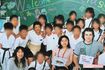 小学生時代、外国人の先生たちと。白いまわしを締めている炎鵬、左下が担任だった指江柚三子さん