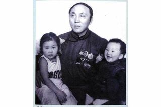父・ムンフバルトさんに抱かれて笑う、2歳ごろの白鵬（右）。左は3番目の姉