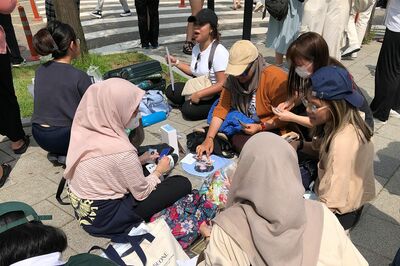 東南アジアと思われる地域からのファンの姿もちらほら。このようなグッズや特典カードの即席交換会があちこちで繰り広げられていた／著者撮影（編集部で一部加工）