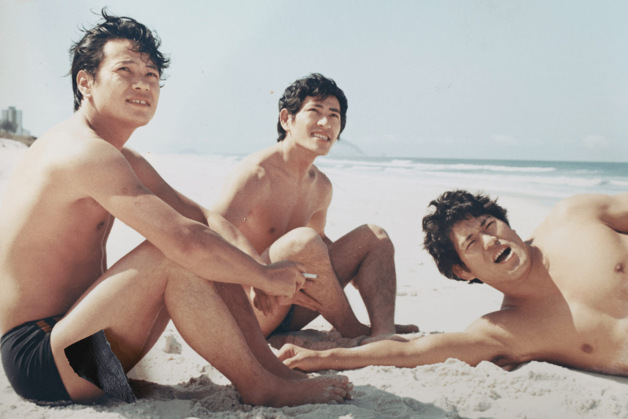 70年代前半、リオのビーチで19歳の啓介さん（中央）とアントニオ猪木氏（右）。左は5男の宏育さん