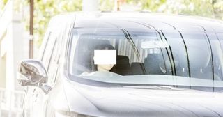 事務所の車に乗って帰宅した向井。後部座席でメガネをかけてマスクを着用