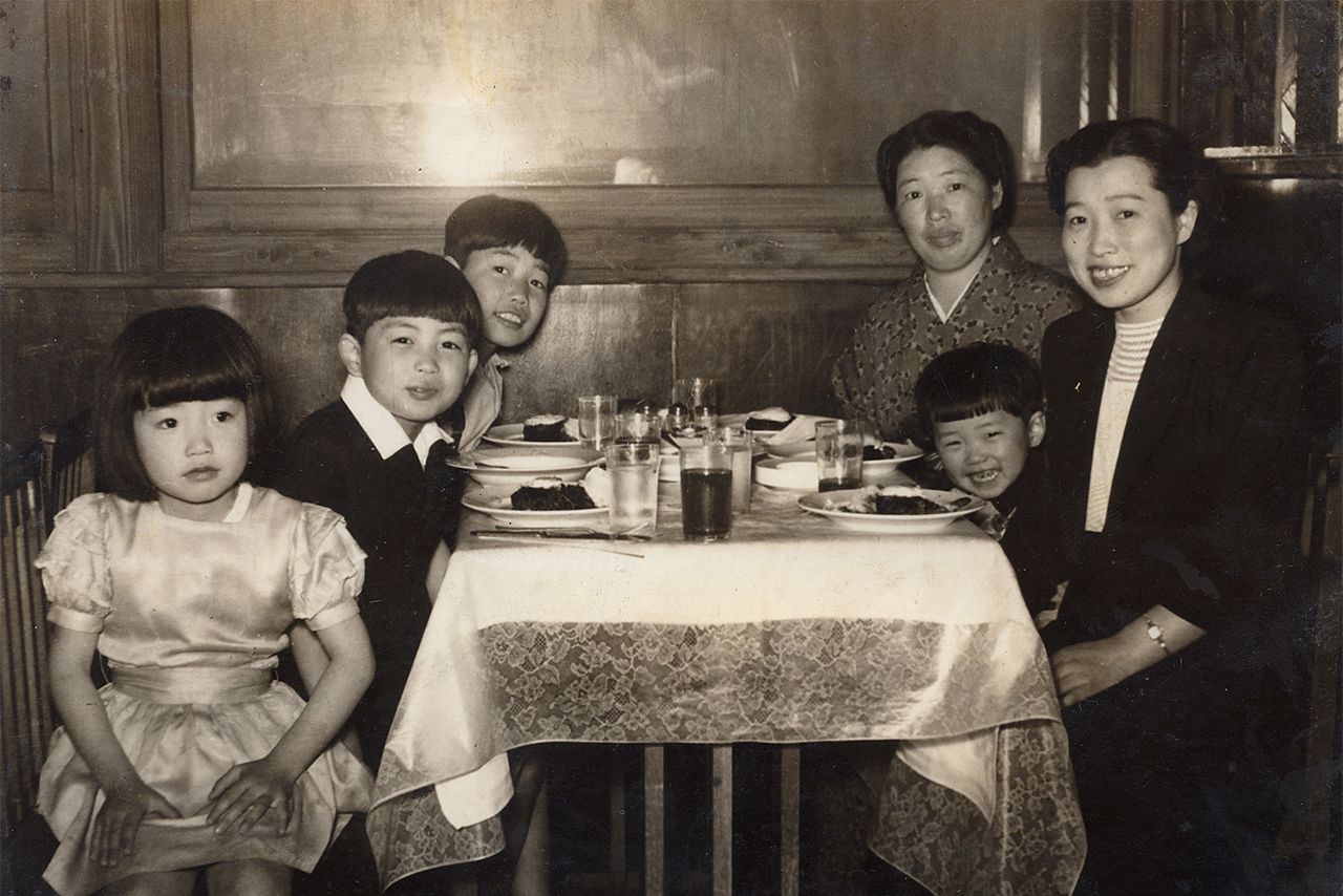 幼少期の家族写真で、右側の母たちに挟まれているのが北原。