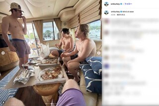 上半身裸の水着姿でピザを食べる村上宗隆（写真中央）。ムキムキな肉体が話題に（ショーン・バーク選手のインスタグラムより）