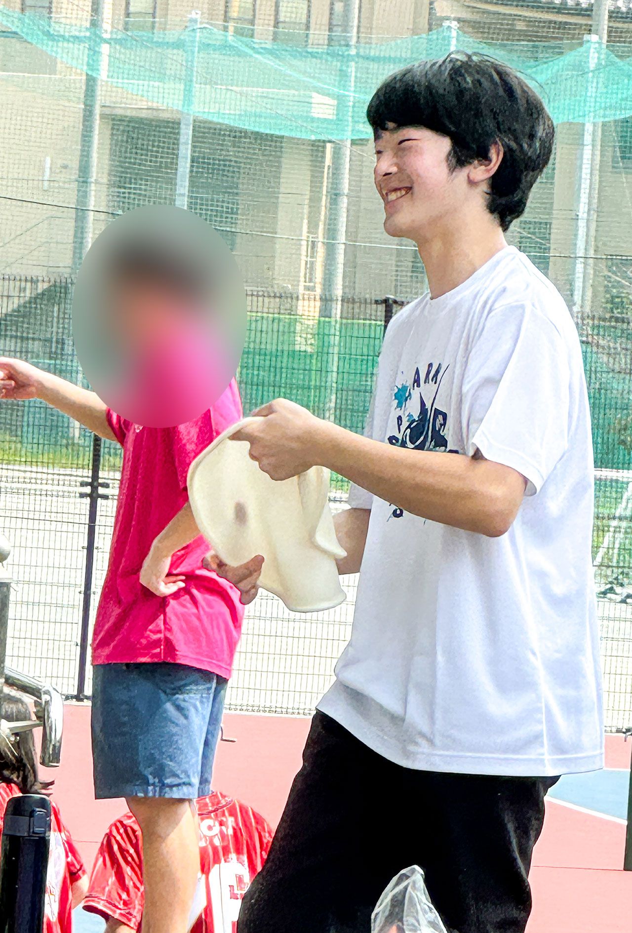 筑波大学附属高校の文化祭で、ご学友とピザ生地のようなものをくるくると回す悠仁さま（来場者提供）