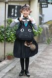 お手製のぬいぐるみや小物を身につけ、本日は全身黒猫風コーディネート! お気に入りの喫茶店の前で。 撮影/坂本利幸