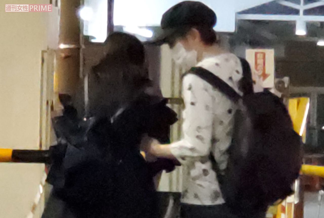 女性と腕を組む小堀裕之